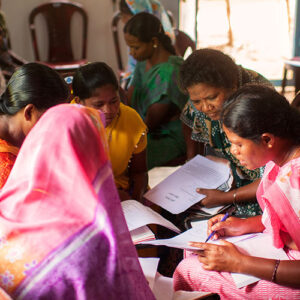 A group of Indian women looking at papers in a discussion