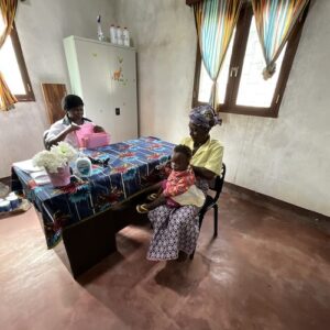 Two women and a child sitting at a table reviewing medical records